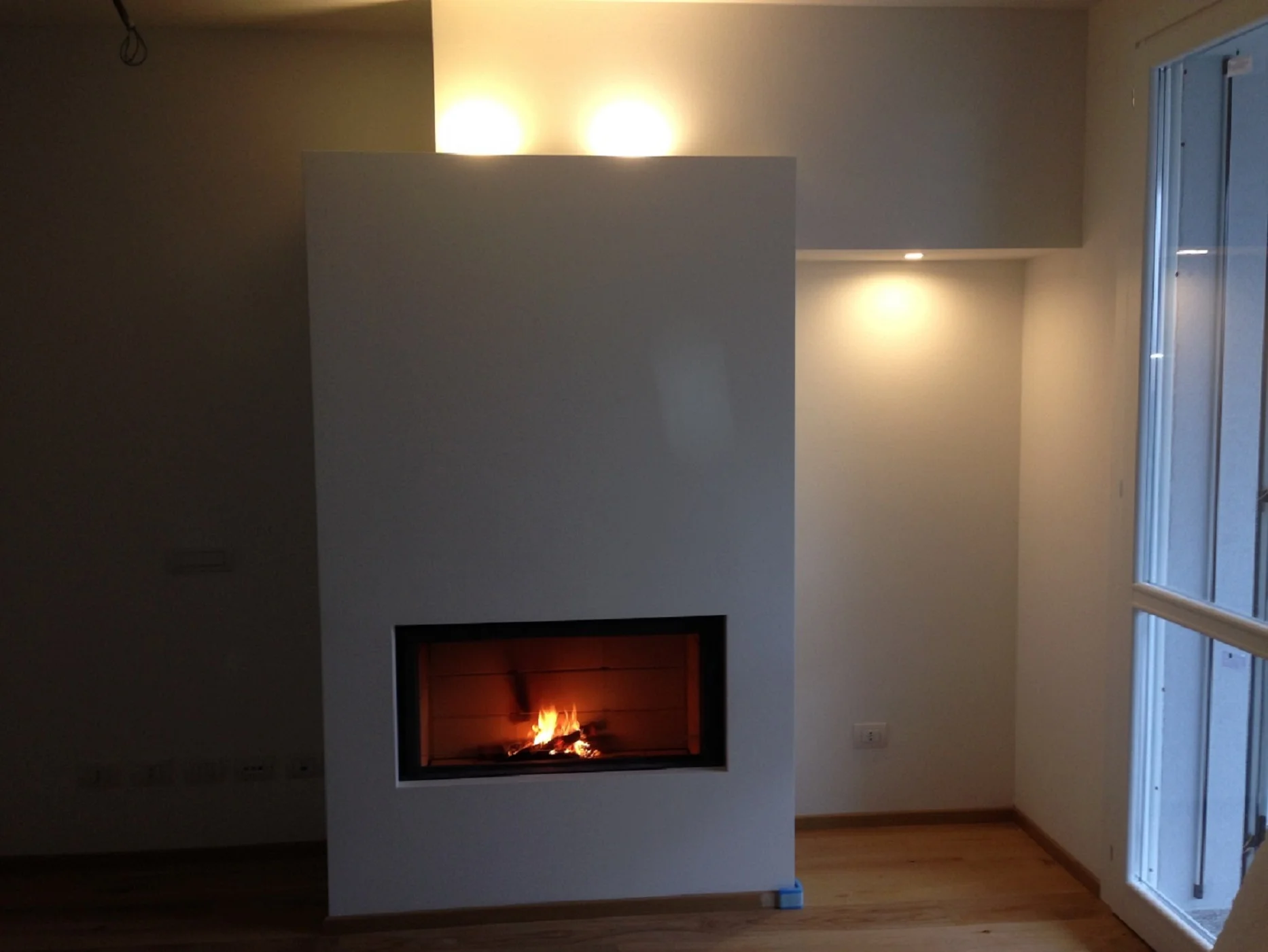 Caminetto Stuv 105 con struttura in cartongesso e faretti